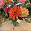 Mixed bouquet with orange gerbera daisies and pink roses in a glass vase