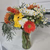 Bouquet of orange, yellow, and white flowers in a glass vase
