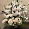 Tall white floral arrangement with roses, lilies, and gladiolus