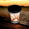 A scented candle in a glass jar with a black lid