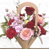 Mixed bouquet of red, pink, and lavender flowers in a kraft paper wrap