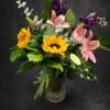 Bright yellow sunflowers and soft pink lilies create an immediate, sunny welcome