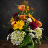 Bright yellow gerbera daisies and soft peach roses create an immediate burst