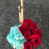Red roses and blue daisies arranged with bamboo sticks