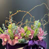 A striking composition of lush orchids ,sculptural greenery ,and artistic branches elegantly