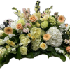 Low floral arrangement with peach, cream, and white blooms