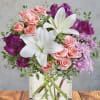 Soft pink roses and large white lilies mingle with vivid purple alstroemeria