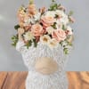 Soft peach roses and blush blooms gathered in a compact, rounded bouquet