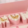 A heart-shaped cluster of white roses set in a pink gift box