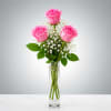 Three bright pink roses take center stage in this elegant flower arrangement