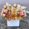 Soft clusters of soft pink roses and peach chrysanthemums create a romantic