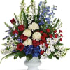 Large mixed floral arrangement in a white pedestal vase