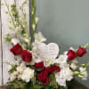 This stunning arrangement is elegantly designed with red roses, gladiolas, orchids, lilies