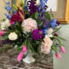 Colorful mixed flower arrangement in a white pedestal vase