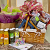 Gift basket with snacks, juice bottles, and a large plaid ribbon bow