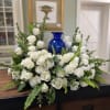 White rose arrangement with ferns and eucalyptus on a table