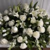Large white floral arrangement with roses and lilies