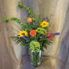 Tall, garden-style mix of orange roses, yellow sunflowers, purple fillers and lush