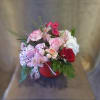 Mixed bouquet in a red hatbox with pink, red, and white flowers