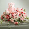 Pink teddy bear surrounded by pink and red flowers