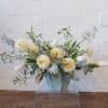 Cream flowers and pale blue blooms in a light blue vase