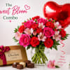 Pink and red flower bouquet in a glass vase with a heart balloon and chocolates