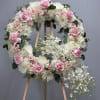 Pink and white floral wreath on a wooden easel