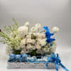 White rose arrangement with blue orchids and small teddy bears in a gift box