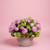 This arrangement features lush pink peonies paired with fresh green and white