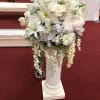 White floral arrangement in a tall pedestal vase