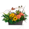 Sunflowers and orange roses in a rectangular basket with a butterfly pick
