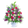 Pink roses and purple flowers in a white pedestal vase