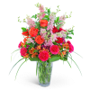 Bright mixed bouquet in a clear glass vase with pink and orange flowers