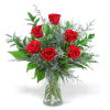 Red roses in a clear glass vase with silver foliage