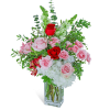 Pink and red roses with white blooms in a clear square vase