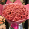 Large bouquet of pink roses wrapped in bright pink paper