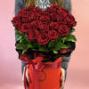 Large bouquet of red roses in a red hatbox with ribbon