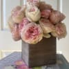 Pink and cream roses arranged in a wooden box