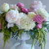 Pink and white roses with hydrangeas in a white pedestal vase