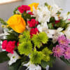 Mixed bouquet with yellow roses, white lilies, pink carnations, and green chrysanthemums
