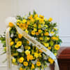 Yellow floral funeral wreath with white ribbon and butterfly accents
