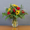 Bouquet of red roses and yellow sunflowers in a clear glass vase