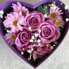 Heart-shaped box with pink roses and daisies