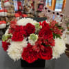 Red and white flower arrangement in a black box with a 