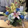 A silk (permanent arrangement) with faux blooms in yellows, blues, and pinks