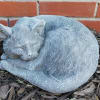 A cuddly curled up cat statue to remember a passed furry friend