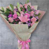 Pink rose and lily bouquet wrapped in patterned paper with a pink ribbon