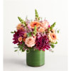 Pink and peach flowers arranged in a green cylindrical vase
