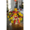 Basket arrangement with a Winnie the Pooh plush surrounded by yellow and red flowers