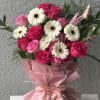 Bouquet of pink roses and white gerbera daisies wrapped in pink paper
